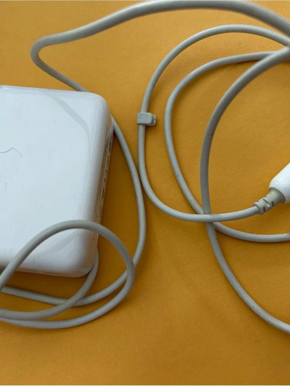 Apple MagSafe power adapter for MacBook laptops.